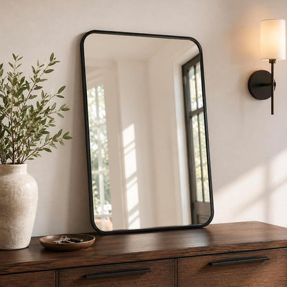 24x36 inch matte black rounded rectangle vanity mirrors on a desk or shelf